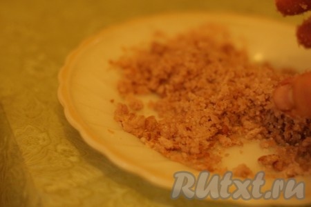 Выкладываем тесто на бумагу для выпечки, формируя тонкий прямоугольник. Сверху наносим слой варенья.  Для приготовления посыпки для нашего тертого пирога отложенные 50 грамм покрошенного печенья смешать с сахаром и маслом.