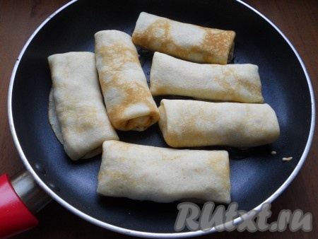 Свернуть блинчик конвертиком или удобным для вас способом. Также подготовить все блины. Затем поместить их на сковороду с растопленным сливочным маслом.
