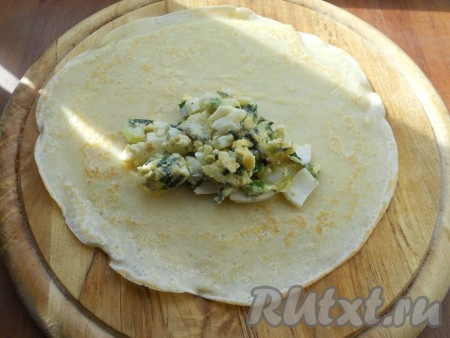 На блин выкладывать 1-2 столовые ложки начинки из яиц и лука.
