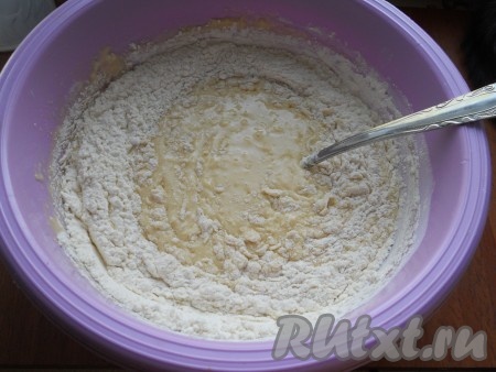 Влить в яичную смесь опару и растопленное масло, перемешать и частями всыпать муку, замешивая тесто.
