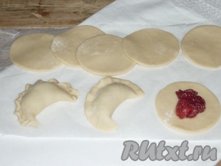 На каждую округлую заготовку выложить небольшое количество вишнёвой начинки и защипать края, формируя вареник. При желании можно сделать на варенике красивую косичку.