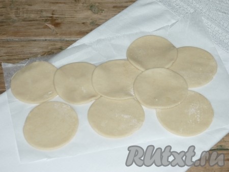 Готовое тесто на столе, присыпанном мукой, раскатать в тонкий пласт, с помощью стакана вырезать круги - заготовки для вареников. У меня диаметр стакана 7 сантиметров, вареники получаются не очень большими и аккуратными.