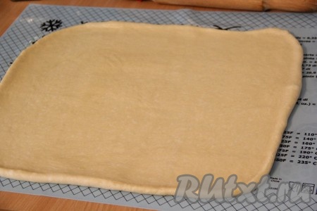 С помощью скалки раскатать тесто в прямоугольный пласт толщиной 3-4 миллиметра.&nbsp;