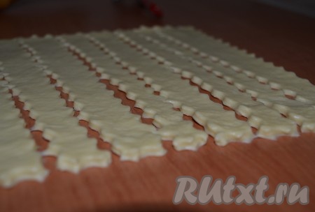 Нарезать тесто на полоски одинаковой длины и ширины. Три полоски отложить в сторону, они понадобятся для формирования ручки пасхальной корзины.
