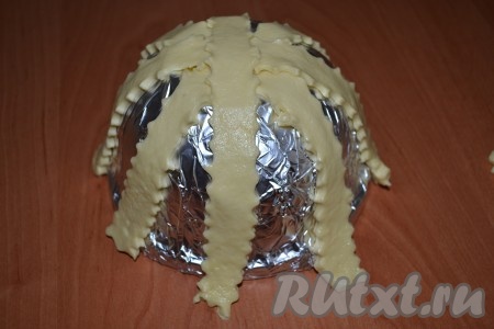 Термостойкую посуду перевернуть вверх дном, обернуть со всех сторон фольгой и по всей длине выложить нарезанные полоски теста.
