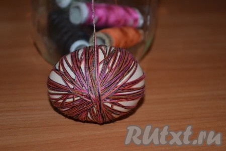 Сырые яйца вымыть и намотать на них в произвольном порядке нитки для шитья.
