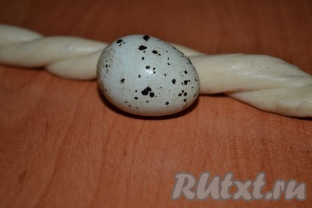 Завернуть начинку внутрь, сформировав вытянутую колбаску. Перепелиные яйца хорошо вымыть и обсушить. Вокруг яйца скрутить колбаску в кольцо. Дать 10 минут "пасхальным гнездышкам" отдохнуть, подняться. Смазать верх взбитым яйцом и посыпать миндальными хлопьями.
