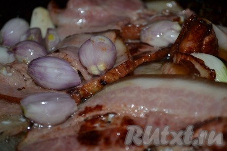 Добавить к бекону очищенный лук шалот (или репчатый лук, разрезанный на 3-4 части) и обжарить ещё 3-4 минуты.
