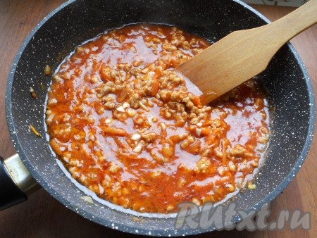 Влить горячую воду, все перемешать, тушить соус на небольшом огне около 5-7 минут. Немного еще посолить и добавить измельченный чеснок, сахар. Перемешать и протушить соус еще около 5 минут.